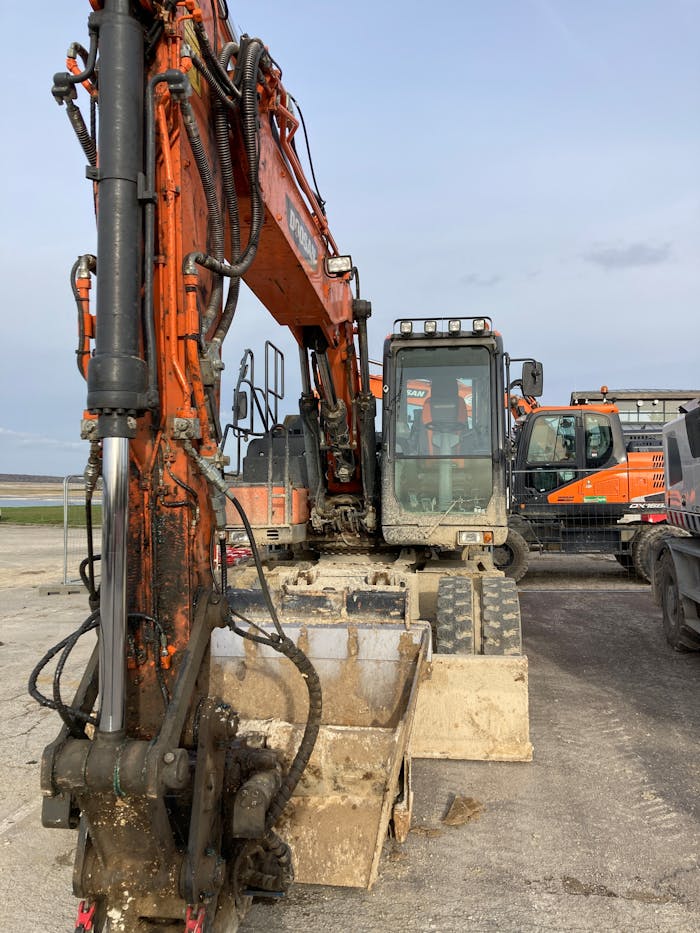 Close-up of an excavator at a construction site, displaying industrial strength and precision.